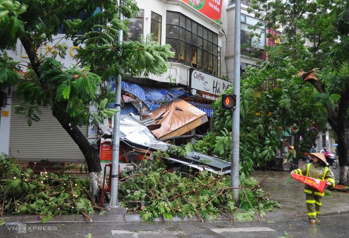 Cành cây gãy va vào mặt tiền nhà hàng khiến biển hiệu bị sập.